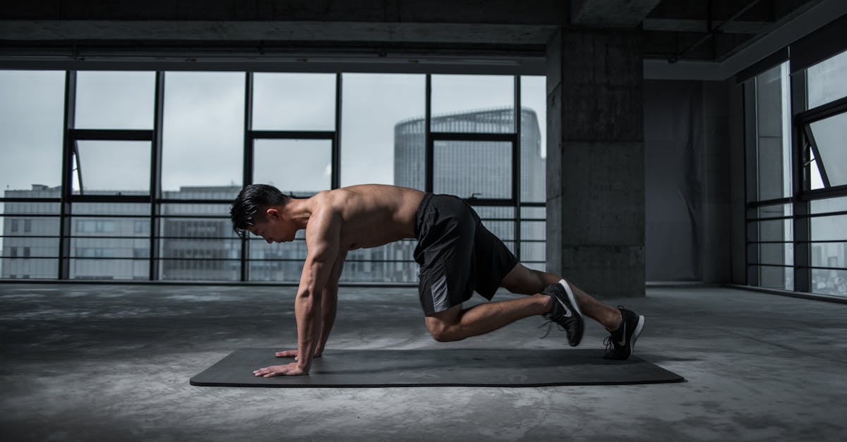 Fit man doing mountain climbers exercise inside a modern gym