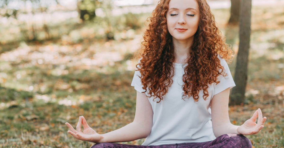 Woman meditating in a serene park during springtime, fostering relaxation and mental wellness.