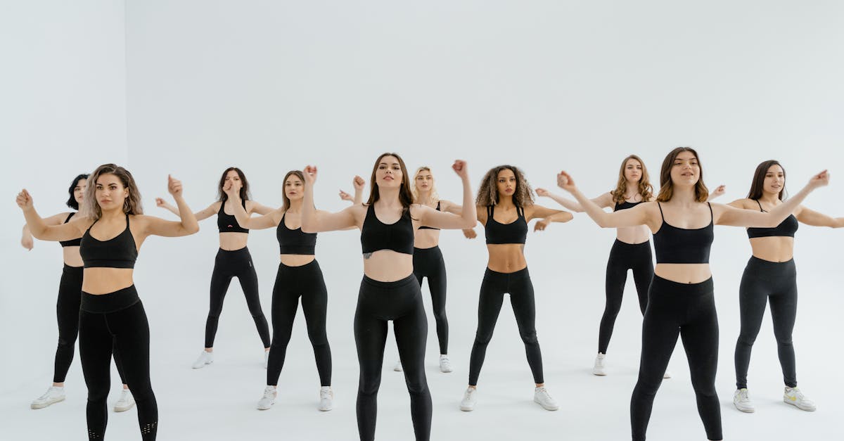 Energetic group of women in black sportswear performing dance routine indoors.